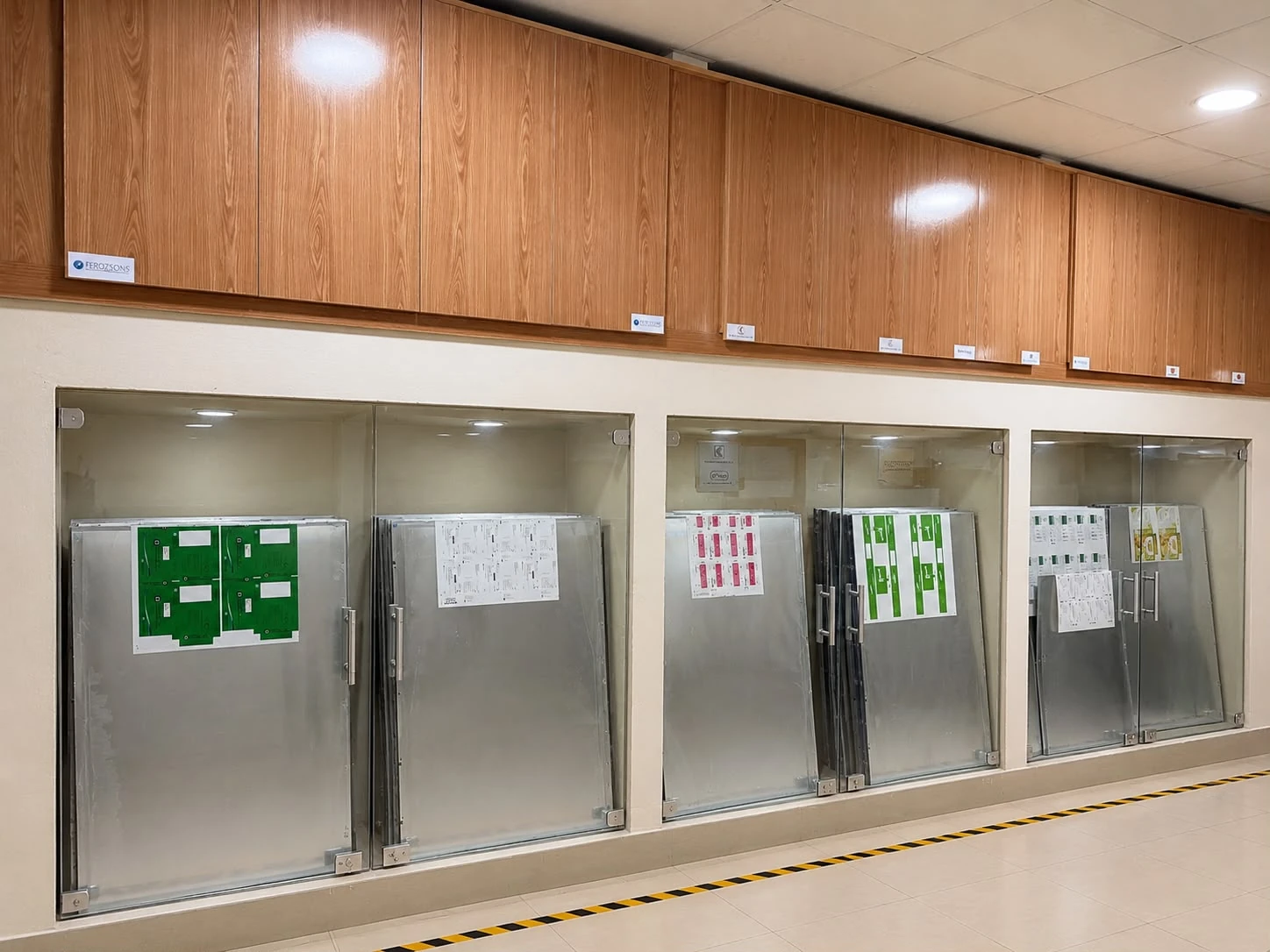 Printing plates stored in labelled glass-fronted cabinets.
