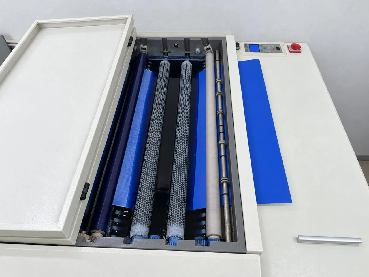 Printing plate passing through processor rollers.